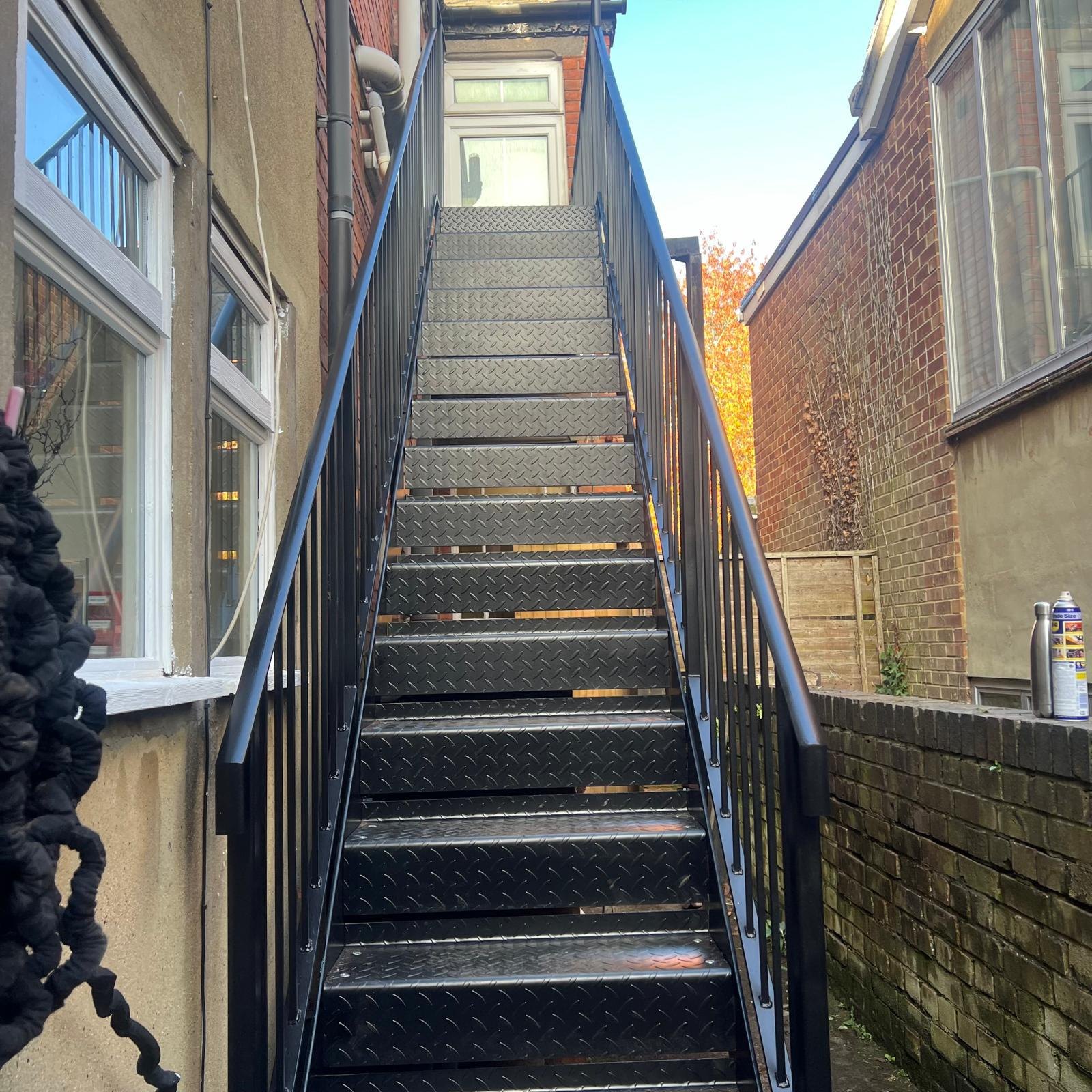 Gap between two houses: single straight flight in black with bar guarding