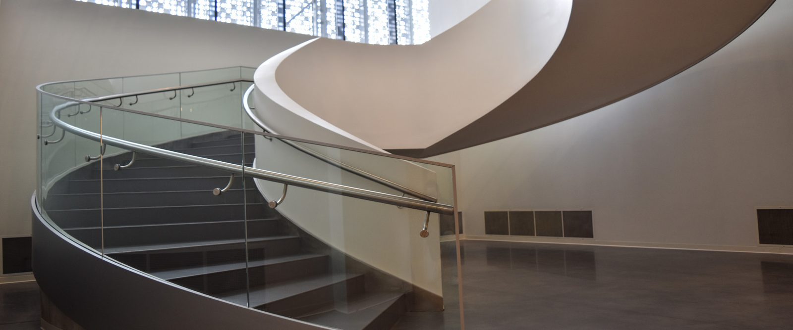 Helical stair in steel, no centre post, sweeping round an open well