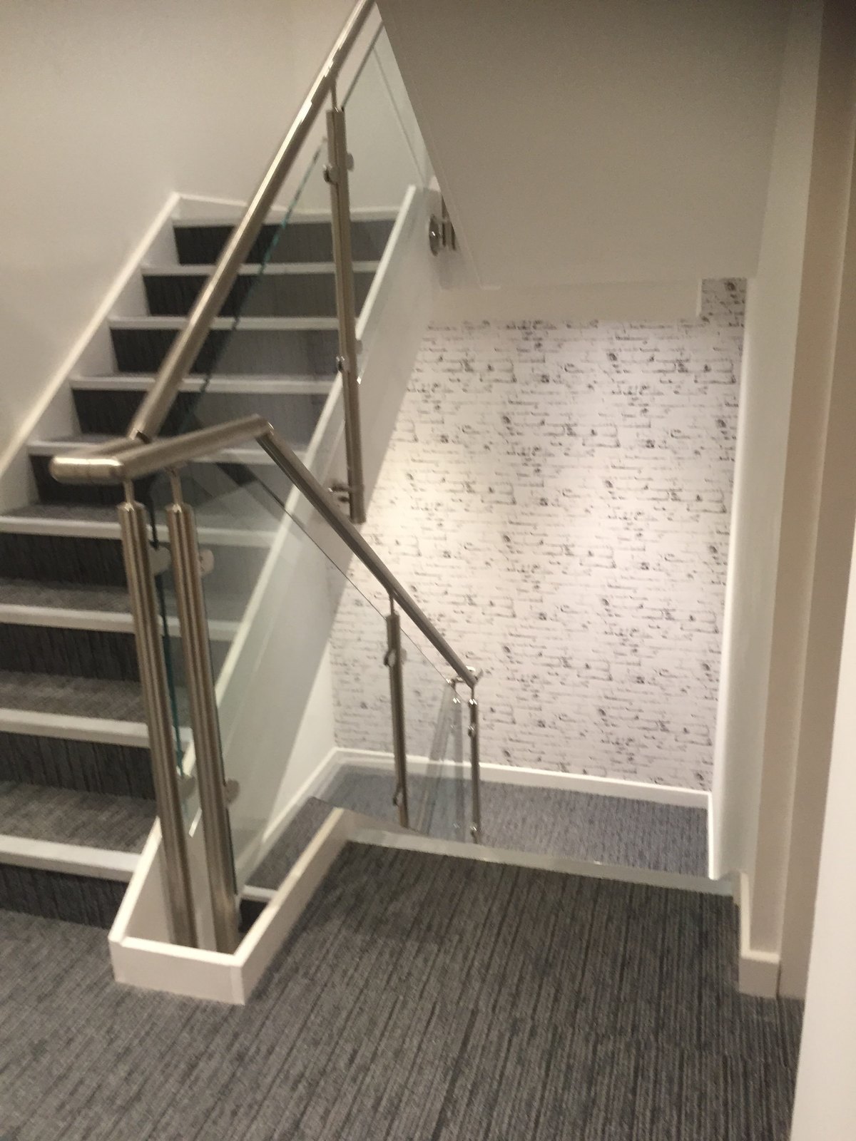 Indoor flight with white strings: glass infill held on satin stainless posts and rail